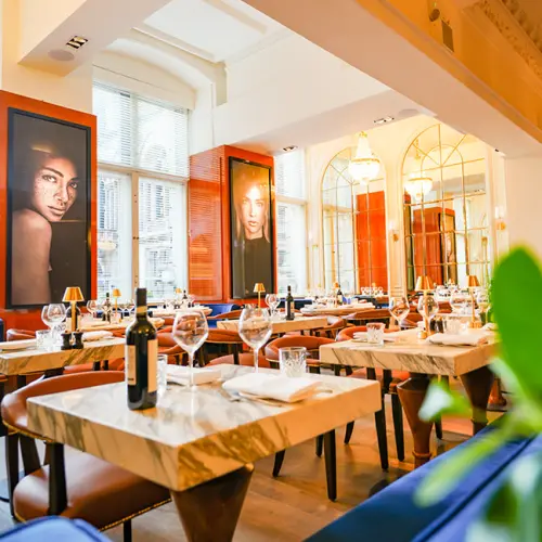 Elegant interior of Cibo restaurant with marble tables and portrait decor