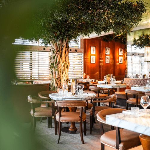 Stylish Cibo-Italian restaurant with marble tables, leather chairs, and warm lighting.