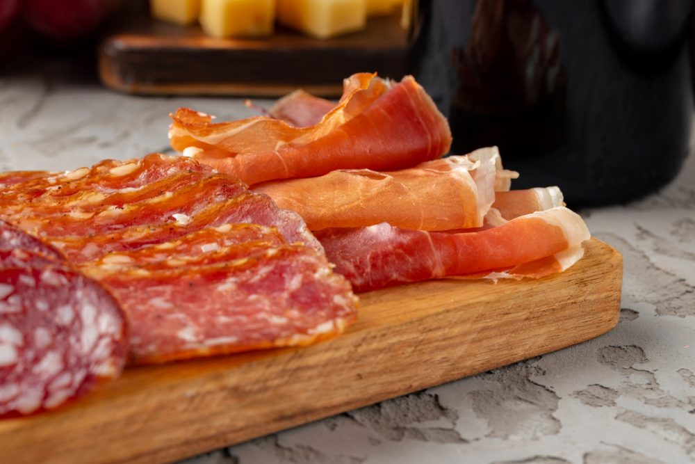 Close-up of meat cuts on a wooden platter.